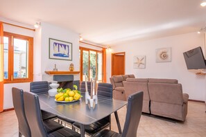 A dining area with a table set for four, a sofa, and a fireplace.