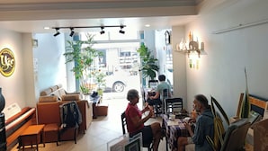 A cozy interior with a piano, seating area, and a view through the glass door. - Yên hostel (Cam Ly - Da Lat)