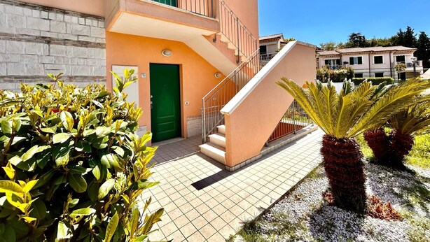 A two-story building with a green door and a staircase leading to the upper floor. - Two-room apartment Leonardo - Sirolo (Sirolo)