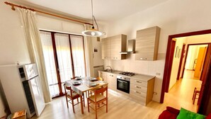 Una cocina moderna con comedor, un sofá rojo y vistas al salón.