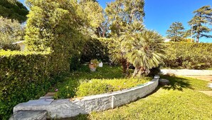 A landscaped garden with a curved stone pathway, various shrubs, and trees. - Villa Margherita, with garden, sea view and wifi (Numana)