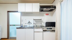 Eine moderne Küche mit weißen Schränken, Edelstahlgeräten und einem eingebauten Backofen.
