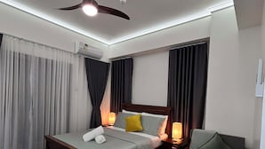 Ett modernt hotellrum med en säng, ett sängbord och en soffa.