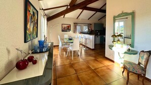 Un'ampia cucina con zona pranzo, caratterizzata da un soffitto in legno, pavimento piastrellato ed elettrodomestici moderni.