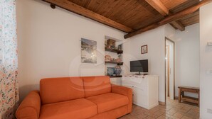 Una habitación con sofá, televisor y una mesita.
