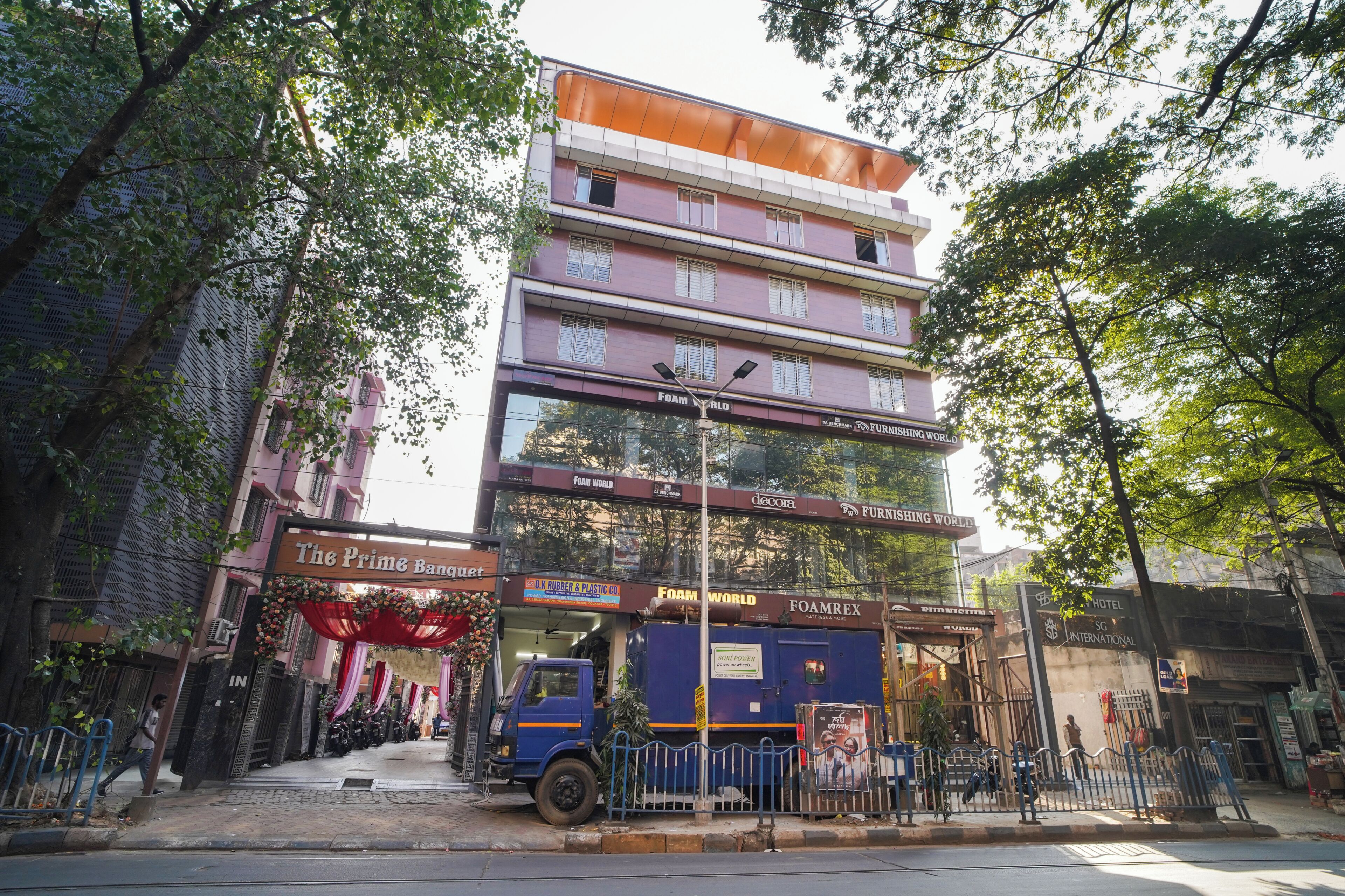 Un edificio de varios pisos con un escaparate que se llama 'The Prime Boutique' y un letrero que dice 'Foam World'.