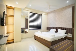 A modern bedroom with a large bed, a built-in TV, and a bedside table.