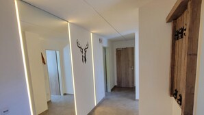 Ein Flur mit einem großen Spiegel, einem Holzschrank und einer Dekoration mit einem Hirschkopf.