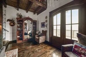 A spacious room with wooden floors, a large window with a view, a bookshelf, and a chair. - High End Design Near Downtown Gatlinburg/Views (Gatlinburg)