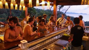 A bar area with a counter, a blender, and a variety of bottles.
