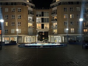 Een meerlaags gebouw met balkons en een centrale binnenplaats met een fontein.