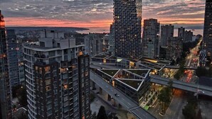 A cityscape with modern high-rise buildings, a prominent tower, and a multi-level overpass. - 29th Floor Condo in Yaletown. Message me at a.hostacny@gmail.com for details 
 (Vancouver)