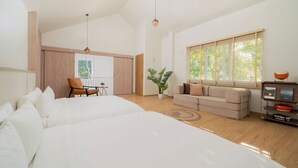 Une chambre d’hôtel moderne avec un grand lit, un canapé, une petite table et une fenêtre avec des stores.
