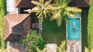 An aerial view of a resort with a swimming pool, palm trees, and a tiled roof. - Sahana Villas (Seminyak)
