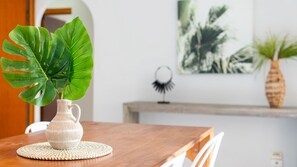 A dining table with a white ceramic pitcher and a large green leaf plant. - Room for Everyone Spacious 4BR Pool Retreat (Kirwan)