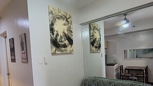 A living room with a zebra-striped sofa, a wooden coffee table with a plant, and two wall-mounted artworks. - 1517 Belvedere Samal View and City View (Davao City)