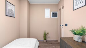 A bedroom with a bed, a potted plant, a dresser, and a door. - Apartment Near Beach With sea View (Porec)