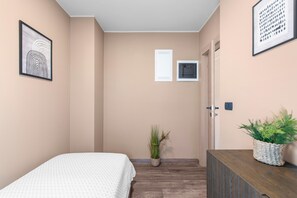 A bedroom with a bed, a potted plant, a dresser, and a door. - Apartment Near Beach With sea View (Porec)
