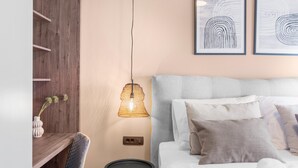 A modern bedroom with a grey upholstered headboard, a bedside table with a lamp, and two framed abstract artworks on the wall. - Apartment Near Beach With sea View (Porec)
