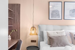 A modern bedroom with a grey upholstered headboard, a bedside table with a lamp, and two framed abstract artworks on the wall. - Apartment Near Beach With sea View (Porec)