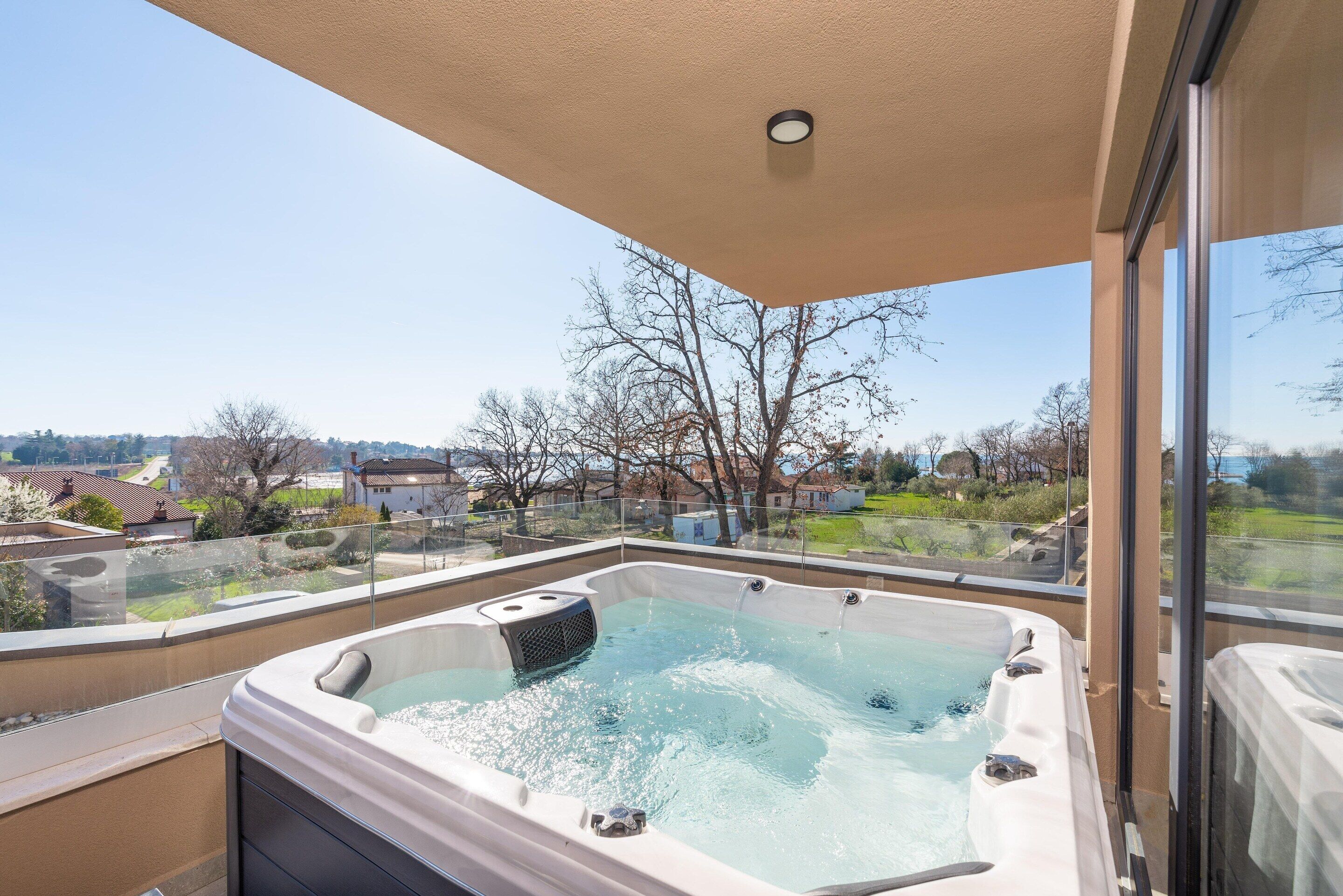A hot tub on a balcony with a clear view of the surrounding neighborhood.