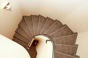 A spiral staircase with a handrail and a light fixture on the wall. - Chalet in Saalbach Near Ski Lift (Saalbach-Hinterglemm)