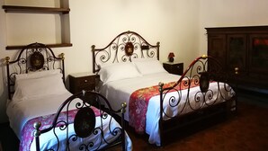 A room with two beds, wooden headboards, a hanging light fixture, and a wooden cabinet. - Charming Villa in Maida With Pool & Garden (San Pietro a Maida)