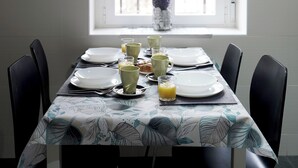 Une table à manger dressée avec des assiettes, des verres et un vase rempli de fleurs.