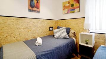 Une chambre avec deux lits, une tête de lit en bois, une table de chevet avec une lampe et deux œuvres d’art murales.