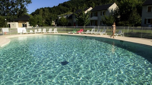 A clear swimming pool with lounge chairs and a fenced area. - Apartment in Saint-geniez by Lot River (Saint-Geniez-d'Olt-et-d'Aubrac)