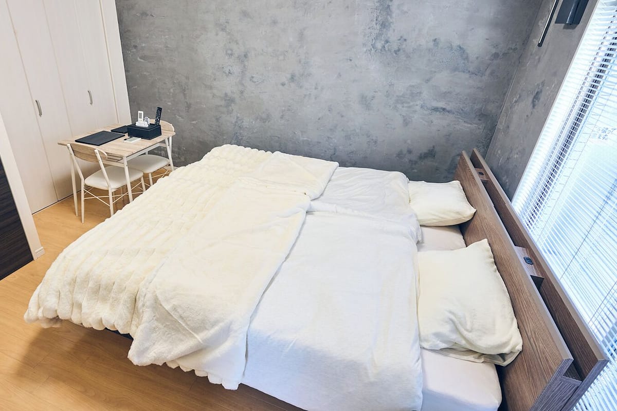 Un dormitorio con cama, escritorio y silla.