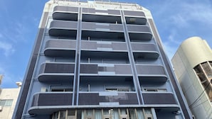A multi-story building with a modern design, featuring balconies on each floor. - Sakurakan (Kagoshima)
