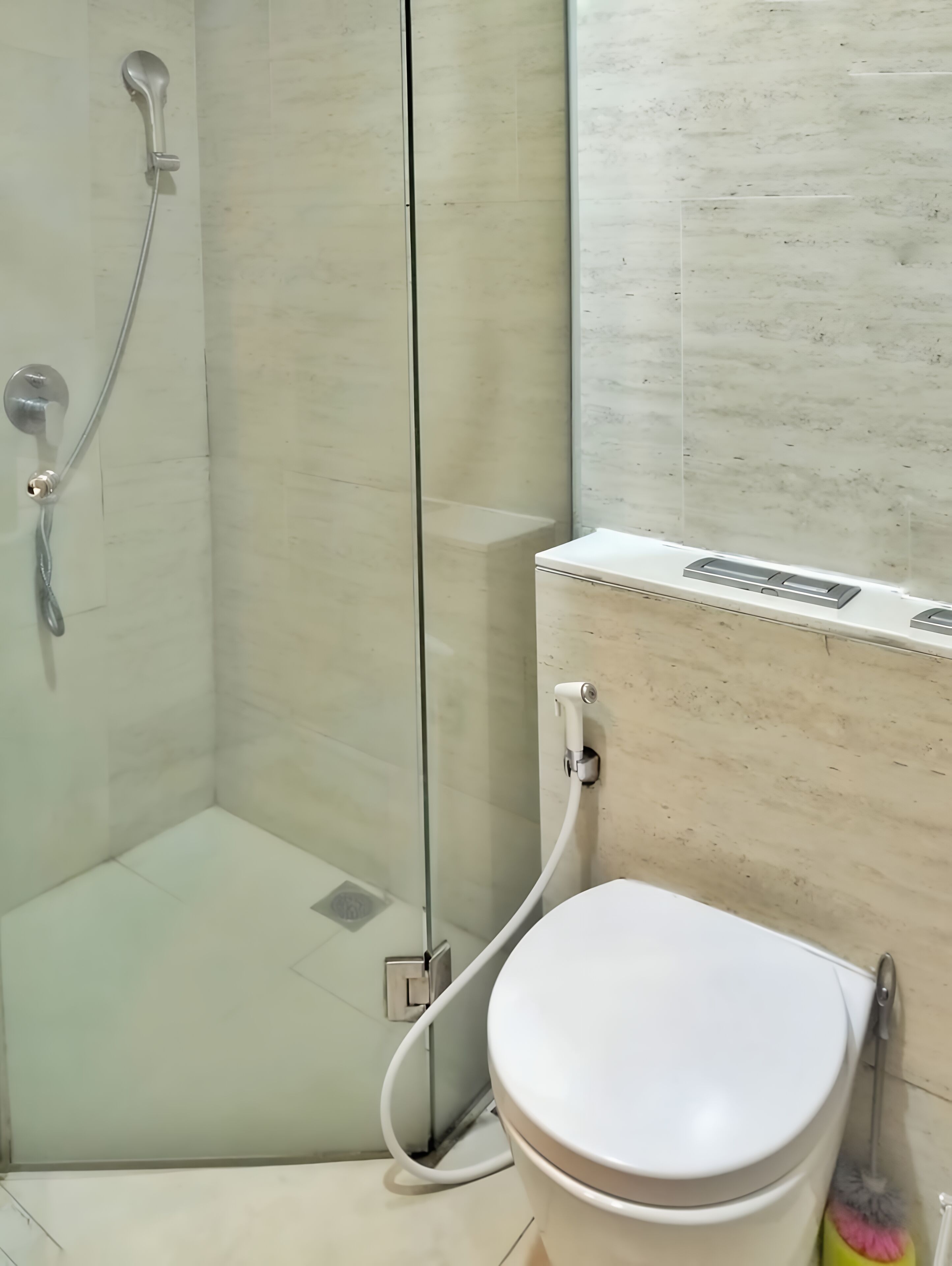 A bathroom with a glass-enclosed shower, a white toilet, and a wall-mounted sink.