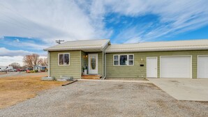Une maison de plain-pied avec un porche à l’avant, un garage et une allée.