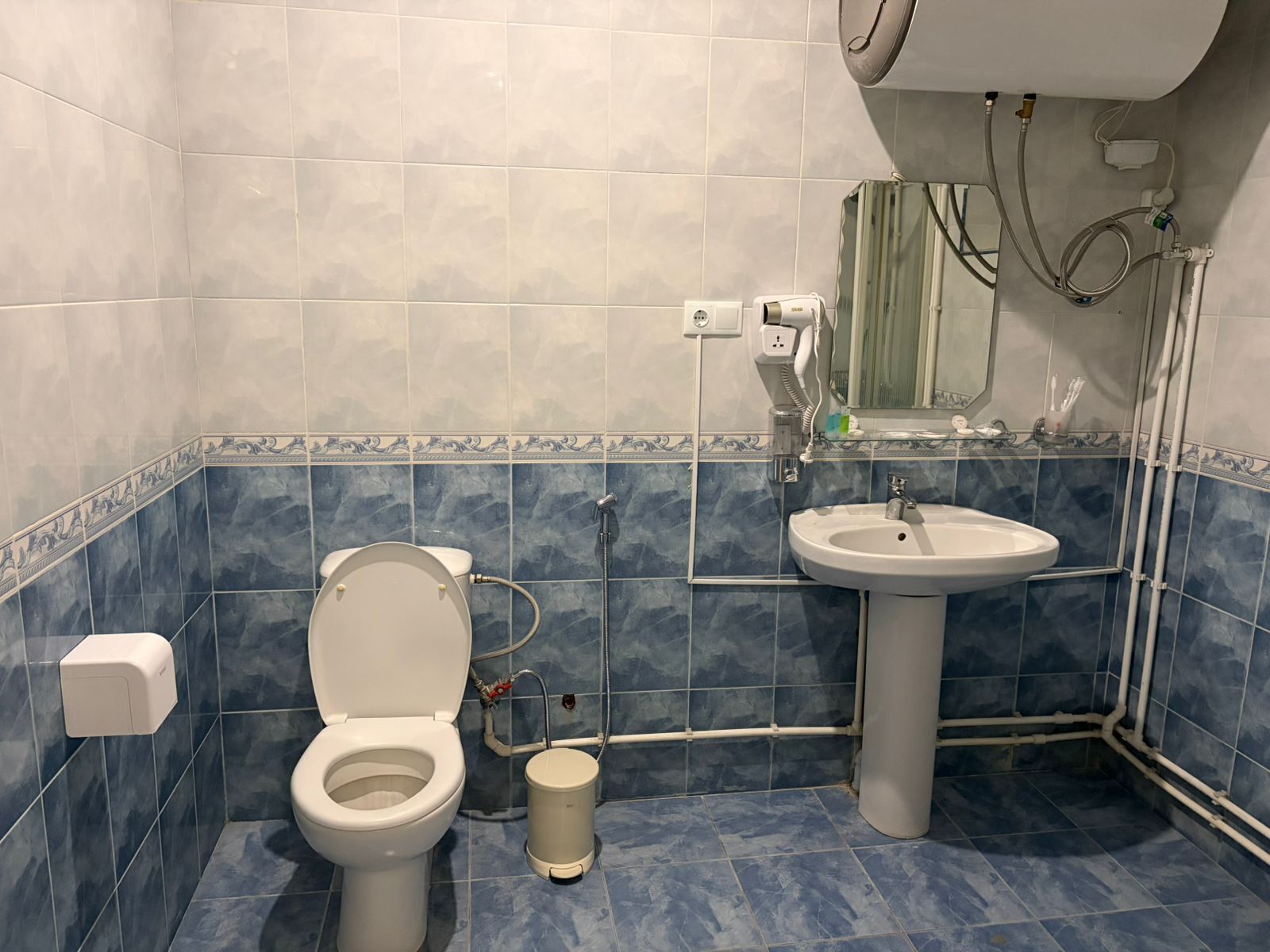 A bathroom with a toilet, sink, and shower.