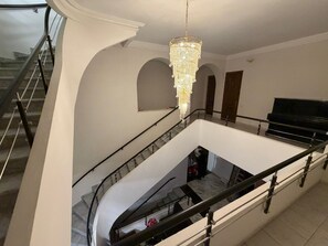 A multi-level interior with a grand staircase, a chandelier, and a piano. - Nana Grand Hotel (Yerevan)