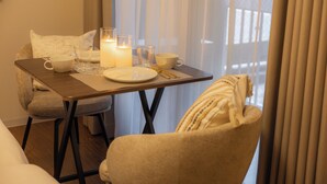A cozy dining area with a table set for two, featuring candles, a cup, and a plate. - BR KUJO - Self Check-In Only (Osaka)