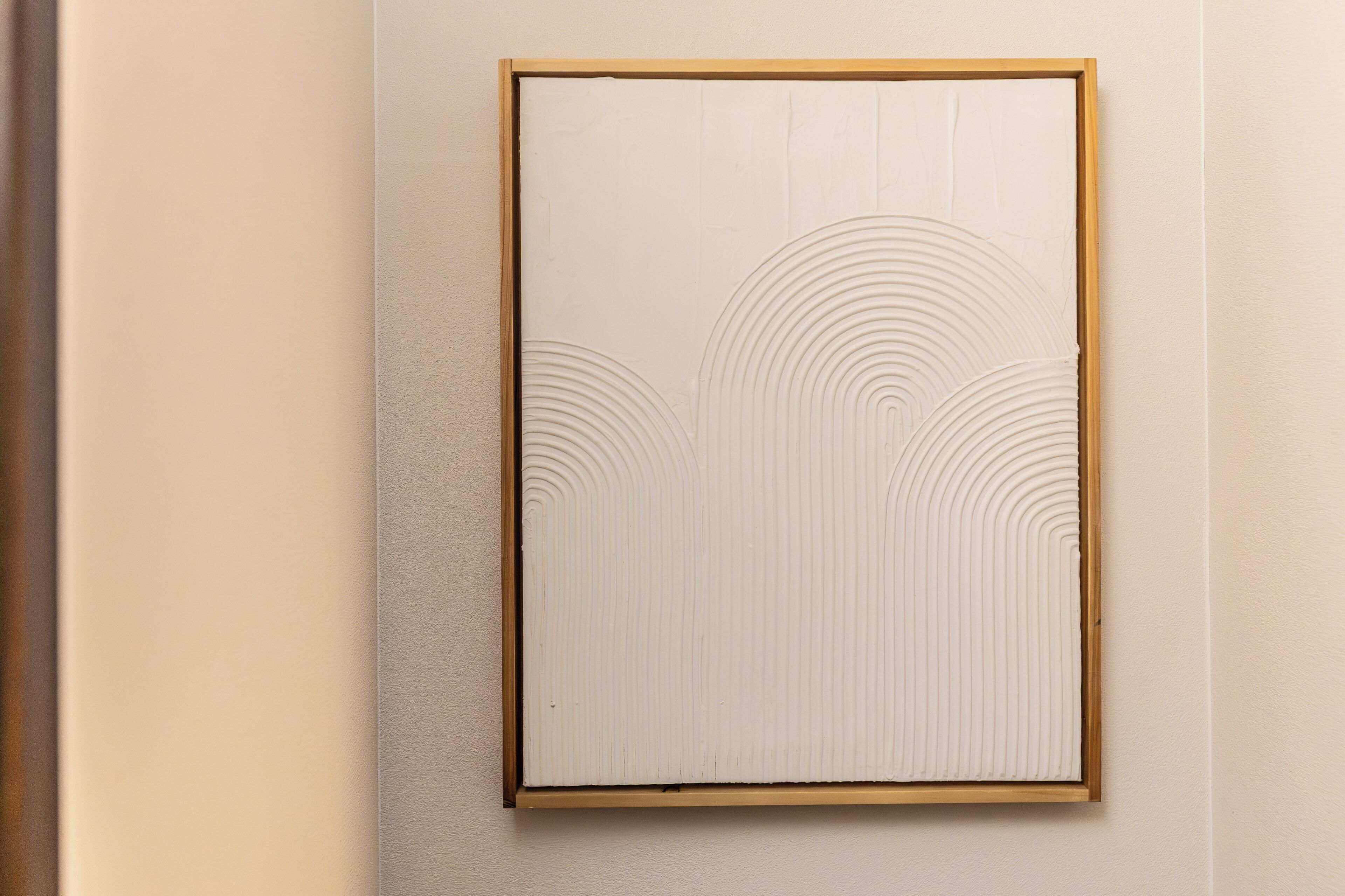 Uma obra de arte emoldurada com círculos concêntricos numa parede com textura.