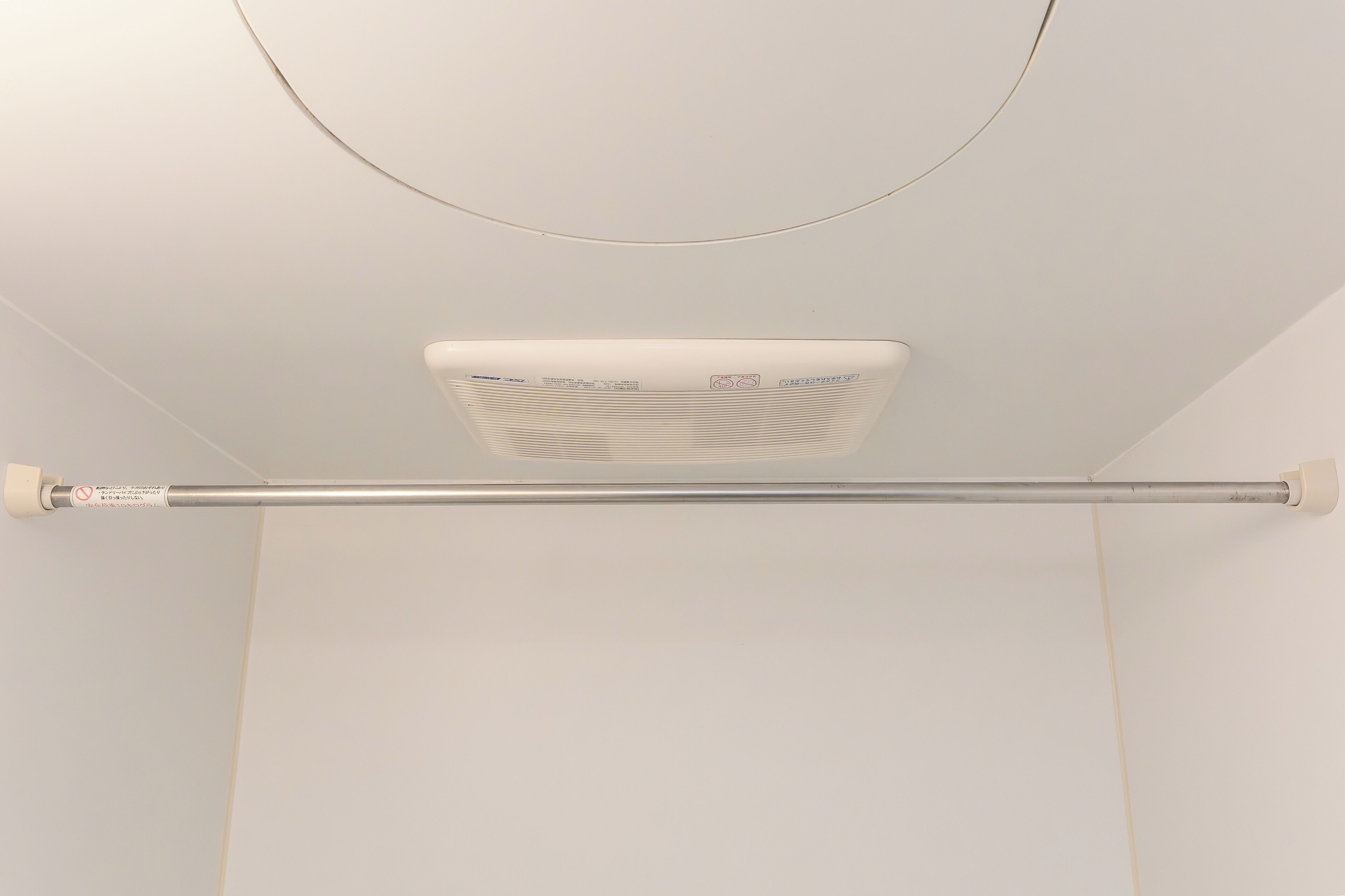 Un equipo de aire acondicionado instalado en el techo, con panel de control visible y conducto horizontal.