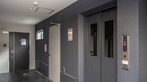 A modern elevator with a digital display and a door with a window. - BR KUJO - Self Check-In Only (Osaka)