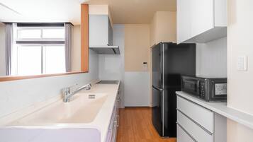 Apartamento | Cocina privada | Frigorífico, microondas, placa de cocina y trona infantil