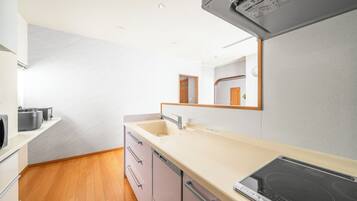 Apartamento | Cocina privada | Frigorífico, microondas, placa de cocina y trona infantil