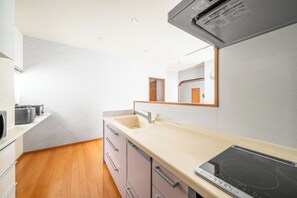 Apartamento | Cocina privada | Frigorífico, microondas, placa de cocina y trona infantil