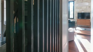 Ein modernes Interieur mit Treppe, Wohnbereich inklusive Fernseher und einer Steinwand.