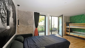 Ein modernes Zimmer mit einem Bett, einer Bank und Blick ins Freie.