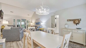 Un salon moderne comprenant un coin repas, un escalier et une vue sur l’extérieur.