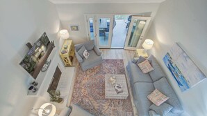 Un vaste espace de vie comprenant un grand canapé, une table basse et un tapis à motifs.