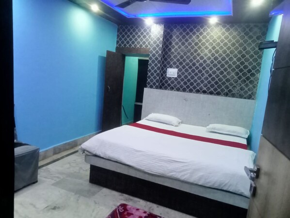 A bedroom with a bed, a nightstand, and a door.