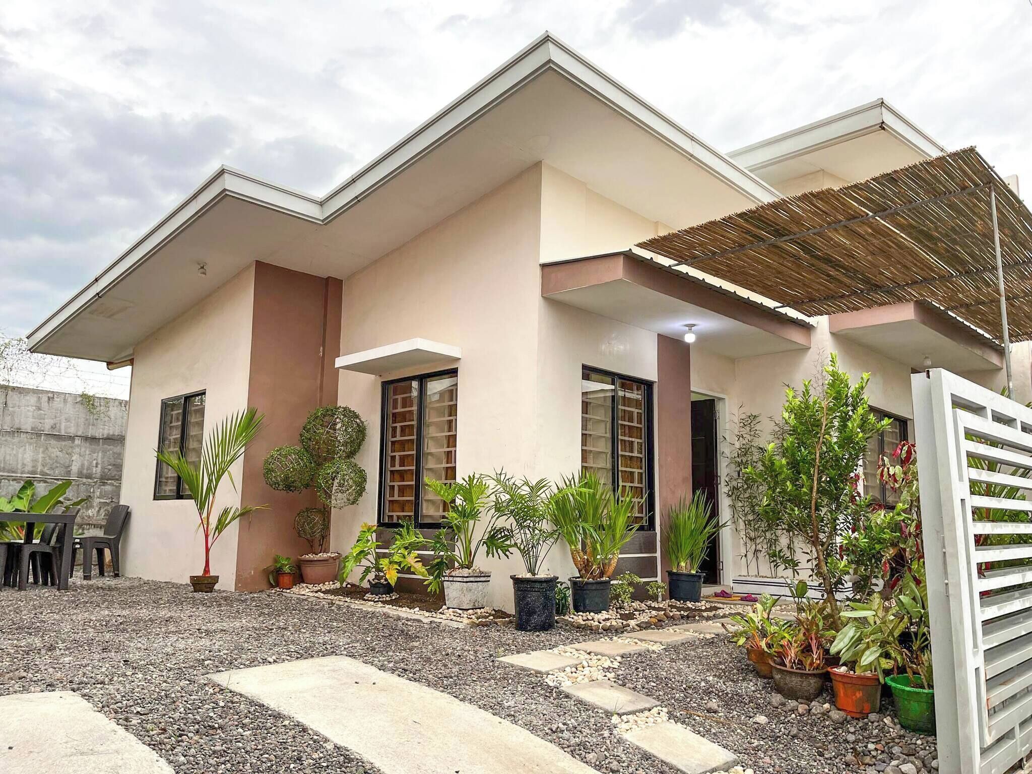 A modern house with a flat roof, large windows, and a covered porch area.