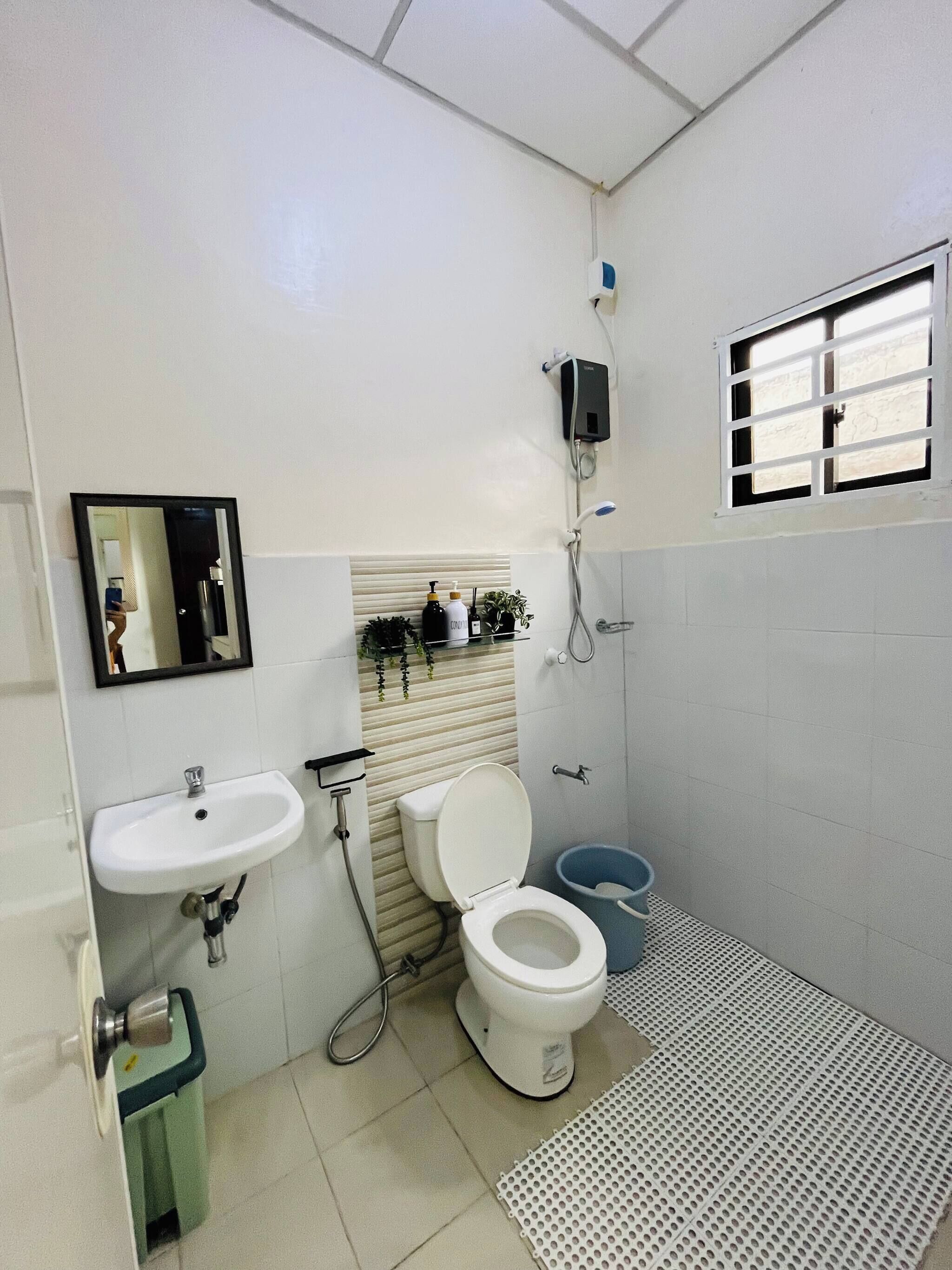Un bagno dotato di lavandino, WC, doccia e finestra.